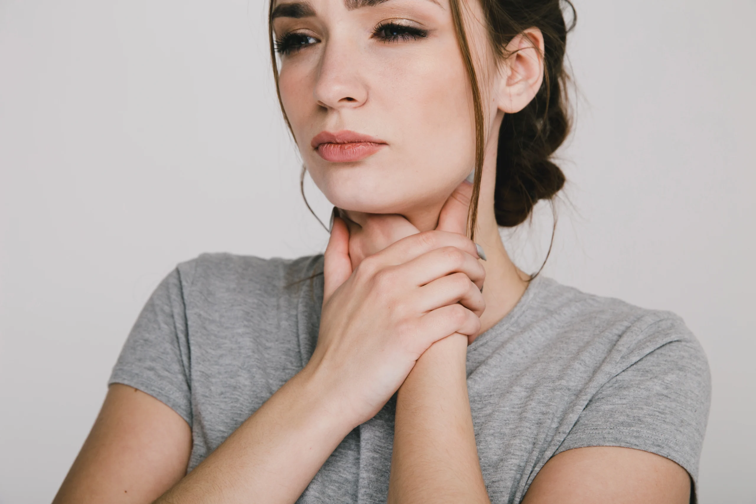 kobieta trzyma się za przełyk z grymasem świadczącym o zgadze