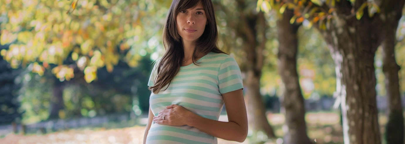 kobieta w ciąży w letniej koszulce stoi w parku